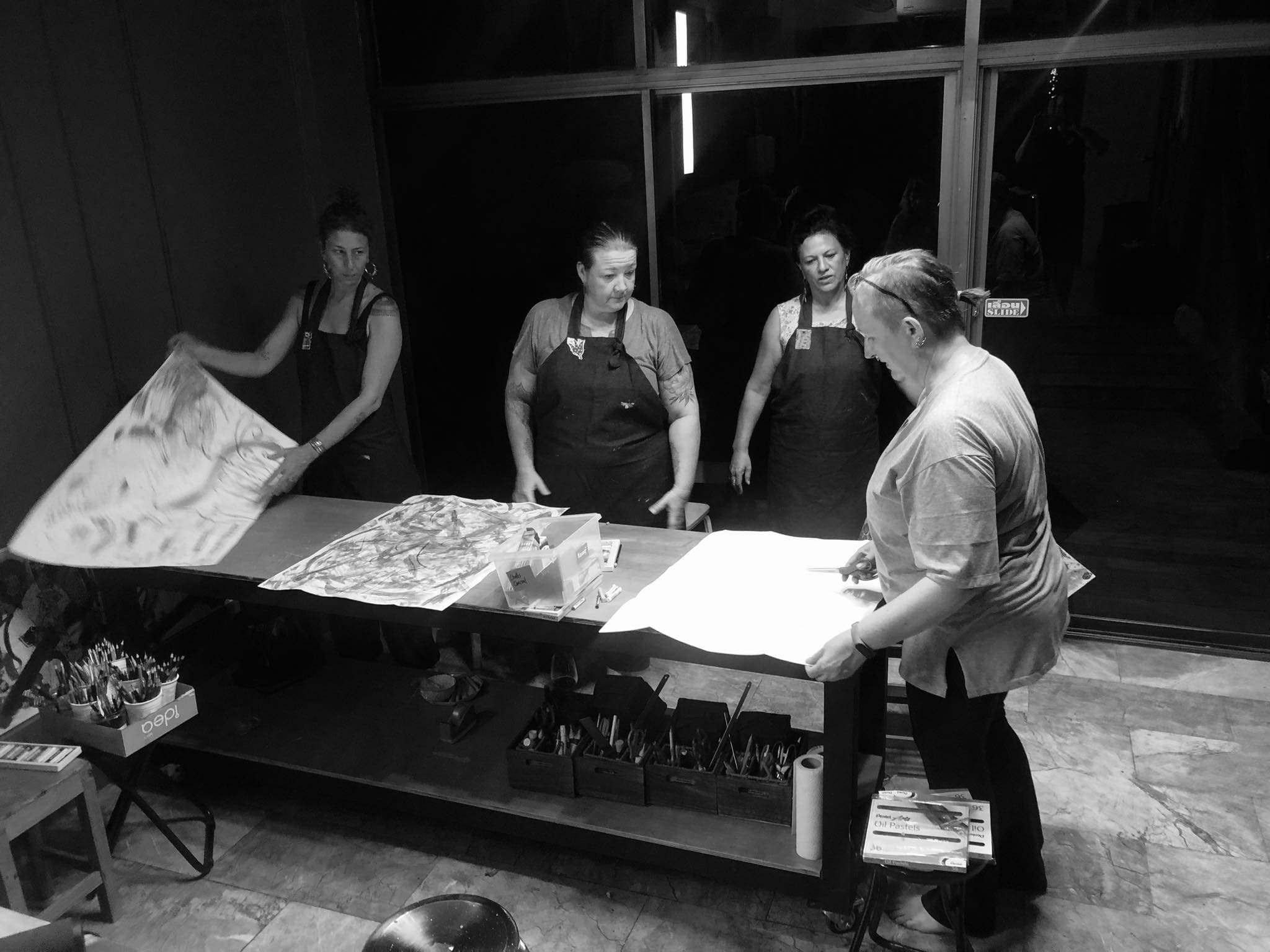 Adults looking at prints, black and white