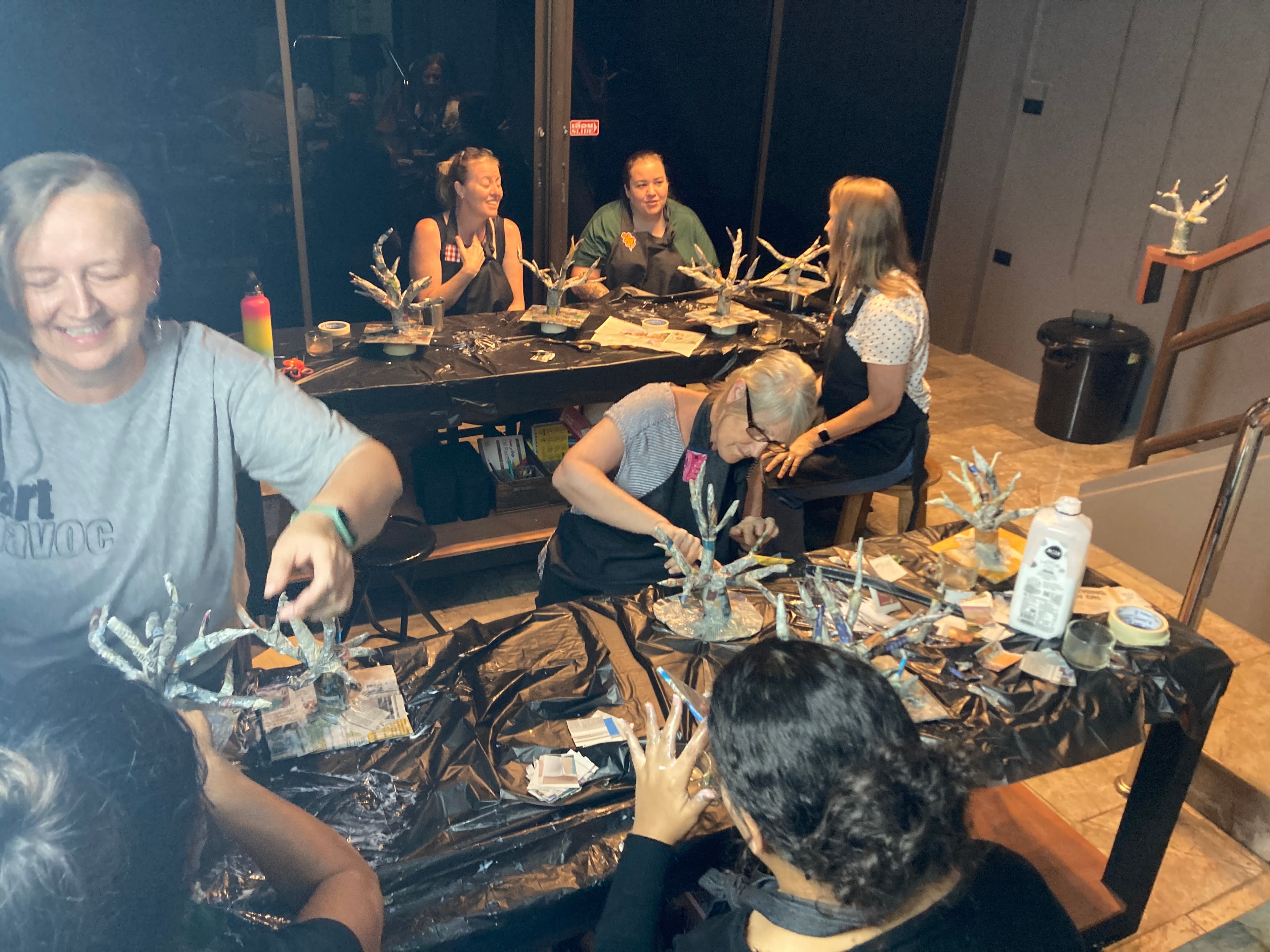 Adults making paper trees together, laughing