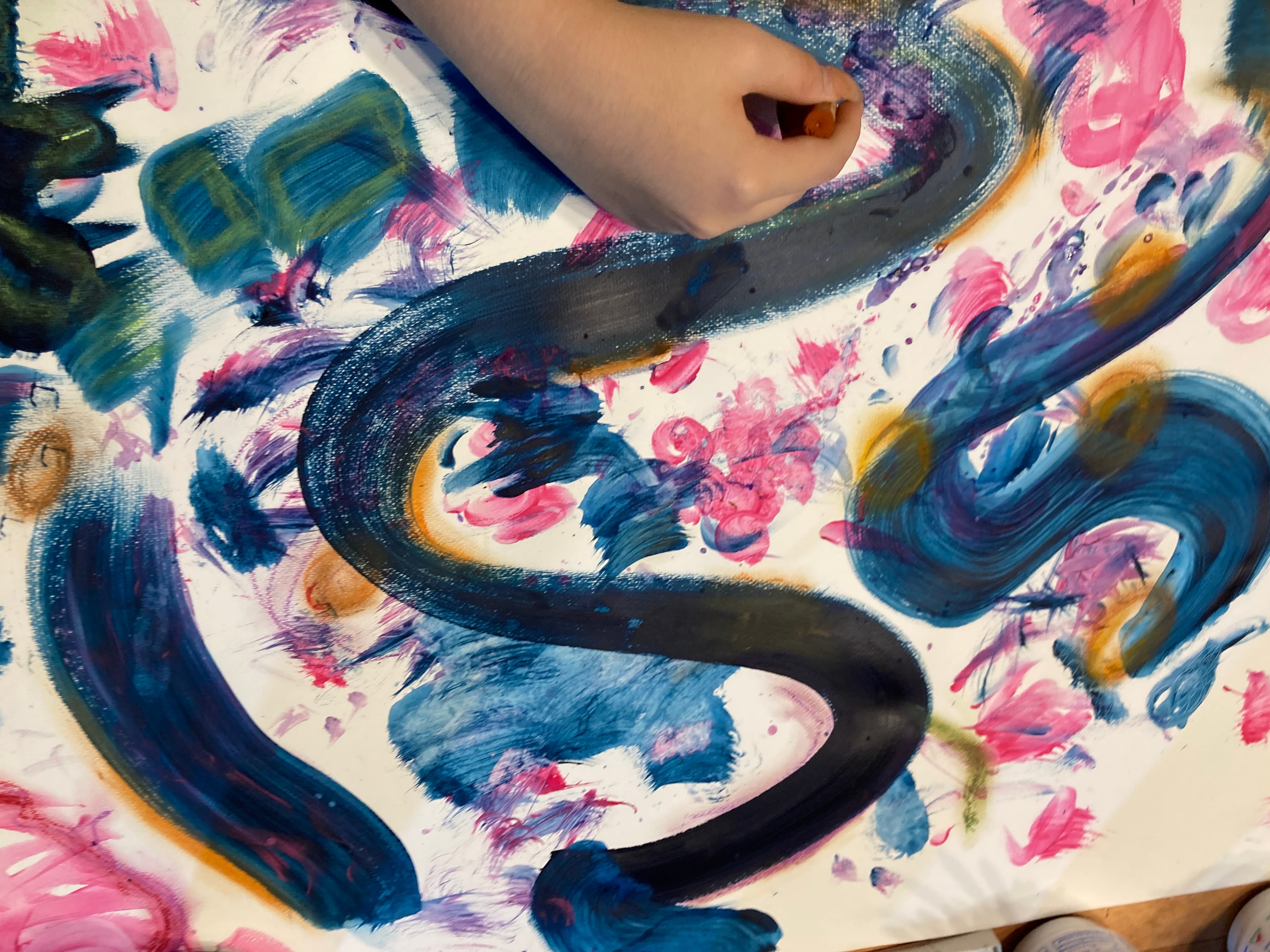 Child's hand painting blue swirls
