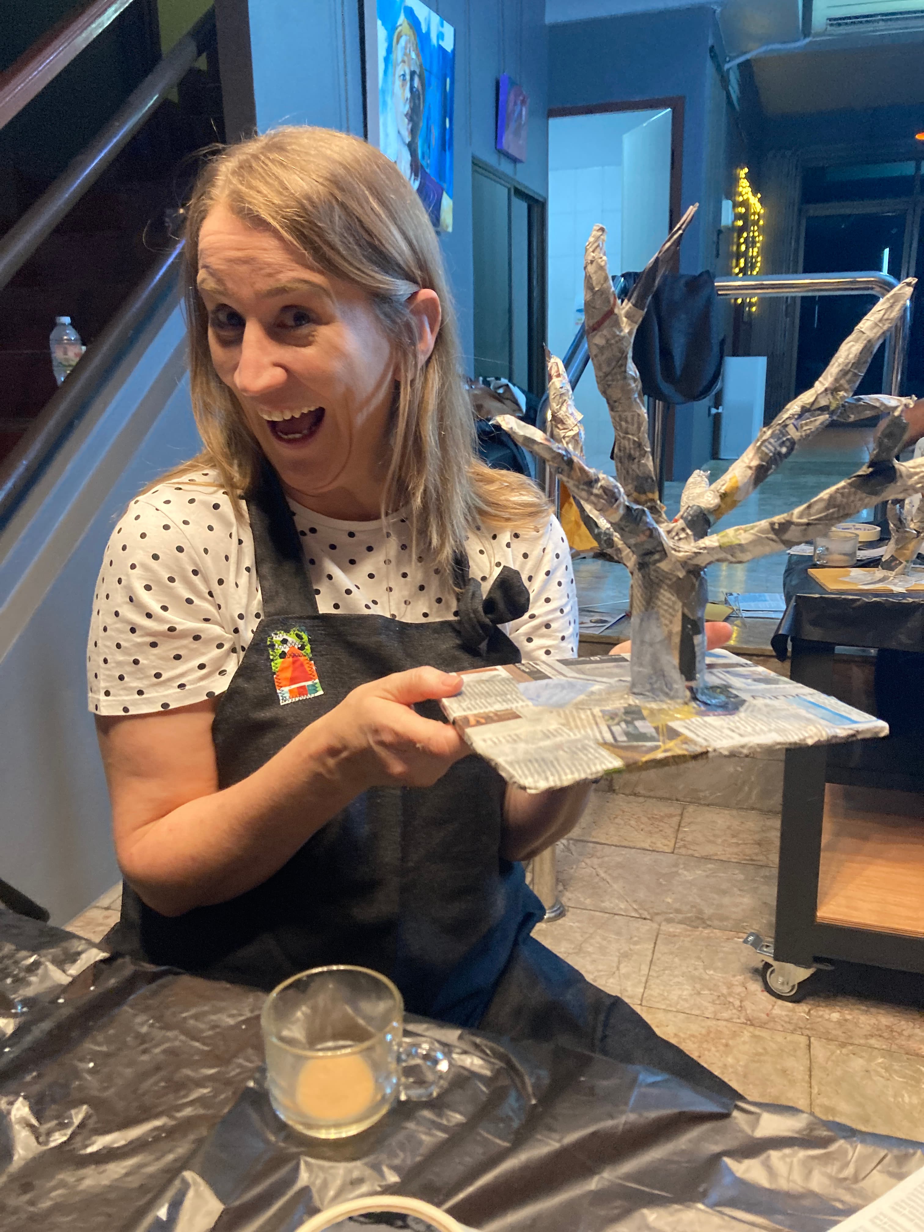 Woman proudly showing her tree sculpture